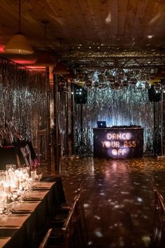 a long table with candles on it in front of a stage set up for an event