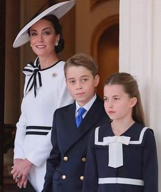 two children and an adult standing next to each other in front of a door wearing uniforms