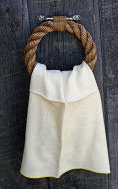 a white towel wrapped in a rope hanging on a wooden wall