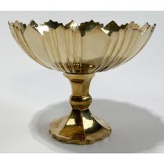 a golden metal bowl on a white surface