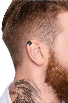 a man with a tattoo on his neck is looking to the side while wearing an earpiece