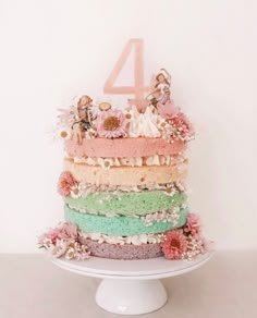 a multi layer cake sitting on top of a white plate next to a number four sign