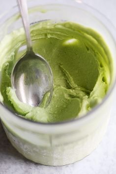 a spoon in a bowl filled with green ice cream