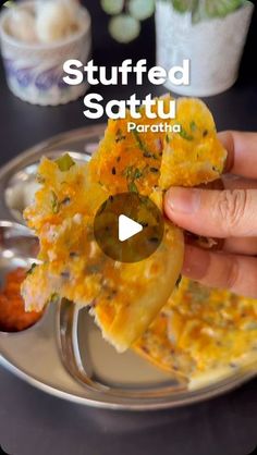 someone is holding up some food on a silver plate with the words stuffed sattu