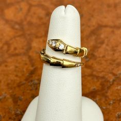 Vintage 18KT yellow gold segmented bypass snake ring with cubic zirconia stones. Size 5 Weight: 4.30 grams Width: 14mm Solid 18k gold Cubic zirconia stones Excellent condition Stamped 18k Gold Diamond Snake Ring Fine Jewelry, Gold Snake-shaped Diamond Ring, Gold Snake Ring With Diamond Accents For Anniversary, Yellow Gold Vvs Clarity Snake Ring For Anniversary, Gold Snake-shaped Diamond Ring For Anniversary, Yellow Gold Snake Ring With Diamond Accents For Anniversary, Saint Jewelry, Bypass Ring, Snake Ring