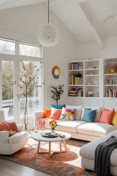 a living room filled with white furniture and lots of windows