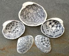 four decorative bowls sitting on top of a cement floor