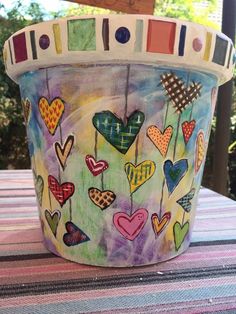 a painted bucket sitting on top of a table