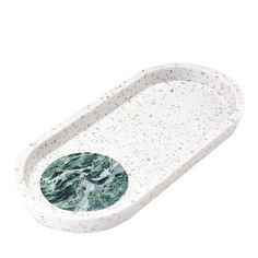 a white and green marble tray with an oval design on the bottom, sitting in front of a white background