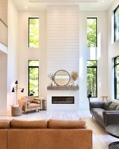 a large living room with high ceilings and lots of windows