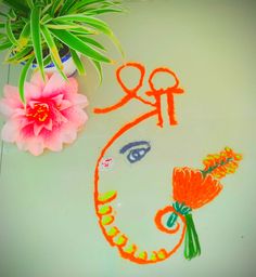 a potted plant sitting on top of a table next to a drawing with flowers