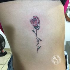 a woman's stomach with a rose tattoo on it