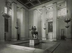 an old black and white photo of a man on a horse in a room with high ceilings