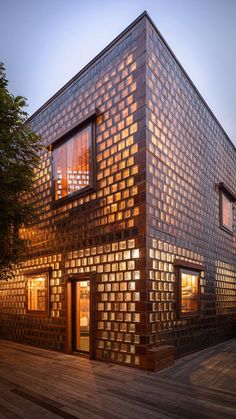 an unusual house made out of bricks and wood is lit up by the light coming from the windows