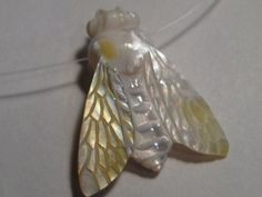 a glass bead with a yellow and white bee on it's back end