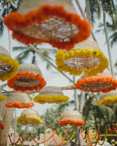 colorful decorations hanging from palm trees in an outdoor setting