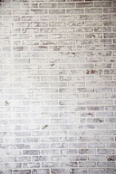 a person sitting on a bench in front of a brick wall with a skateboard