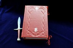 a red book and knife on a blue cloth