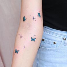 a woman's arm with butterflies and stars tattoo on the back of her left arm