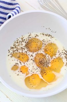 eggs are in a white bowl with seasoning sprinkled around them on a table