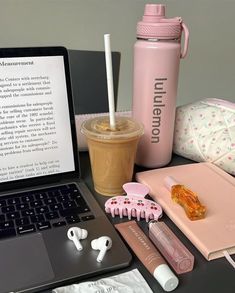 an open laptop computer sitting on top of a desk next to a cup of coffee