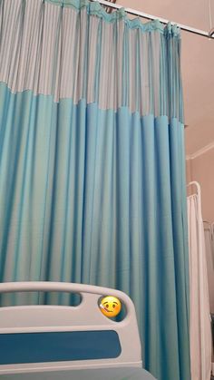 a hospital bed with blue curtains and a smiley face on it