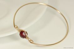 Gold Garnet Red Swarovski Crystal Bracelet Handmade by Jessica Luu Jewelry ~ Alluring ~ Versatile ~ Elegant ~ With every wave of your hand, there will be a sparkle of blood red at your wrist as this bangle moves around. Garnet is the birthstone for January making this a thoughtful birthday gift for someone special. MATCHING ITEMS https://www.etsy.com/shop/JessicaLuuJewelry?ref=seller-platform-mcnav&search_query=garnet+siam MATERIALS: ~ 10mm siam Swarovski crystal ~ 14K gold filled wire HOW I Garnet Bangle Jewelry Gift, Red Adjustable Wire Wrapped Bracelets, Gold Metal Wire Wrapped Bangle, Elegant Wire Wrapped Crystal Bangle Bracelet, Yellow Gold Wire Wrapped Bangle, Garnet Red, Garnet Bracelet, Swarovski Crystal Bracelet, Swarovski Crystal Jewelry