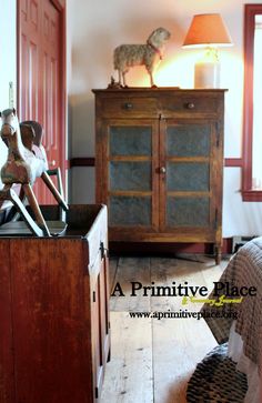 a wooden cabinet sitting on top of a hard wood floor next to a bed and dresser