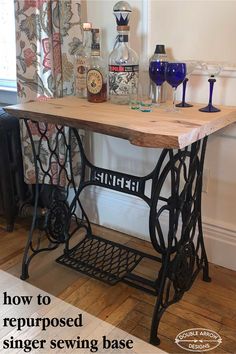 an old fashioned sewing table with wine glasses on top