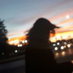 a blurry photo of a person standing in front of a city street at night