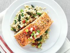 two fish fillets on a plate with rice and vegetables