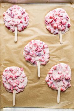 four strawberry marshmallow pops on a baking sheet