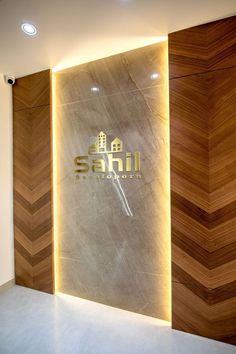 the entrance to an office building with wood paneling and illuminated sign that reads saff