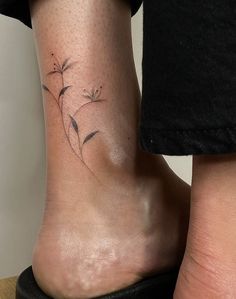 a woman's foot with a small flower tattoo on her left side calfocks