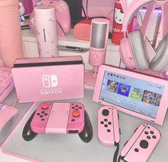 a pink nintendo wii game system sitting on top of a table next to other items