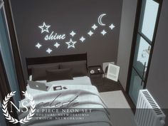 a bed room with a neatly made bed and stars on the wall