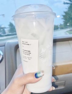 a woman holding up a starbucks cup in her hand with a note attached to it