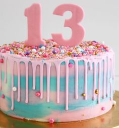 a birthday cake with sprinkles and the number thirteen on it's top