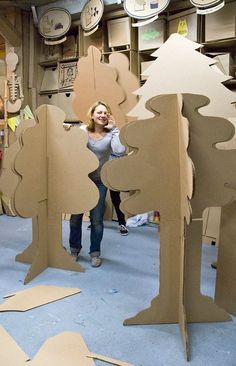 a woman standing in front of cardboard cut out trees