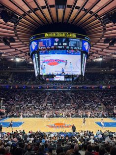 an indoor basketball court with lots of people watching the game on large screen televisions