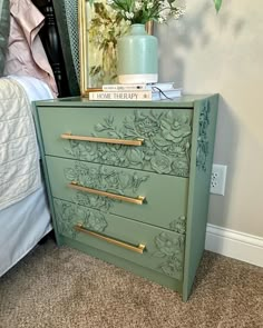 a green dresser with gold handles and flowers on it