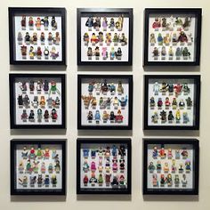 a group of legos are arranged on a wall with black framed pictures above them