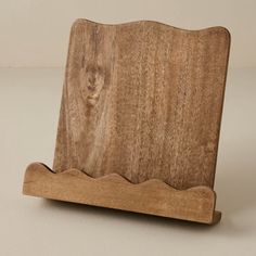 a wooden stand holding a piece of wood with wavy lines on it's sides