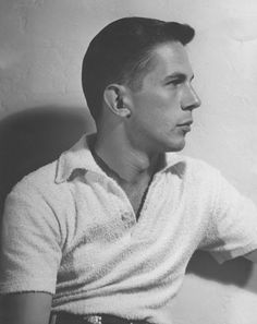 an old black and white photo of a man in a polo - neck shirt looking off to the side