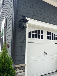 a white garage door on a gray house