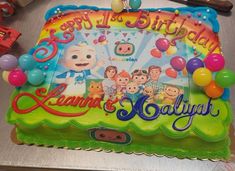 a birthday cake with balloons and characters on it