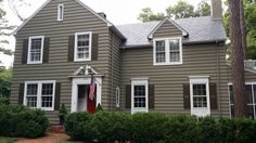 a brown house with white trim and windows