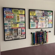 three framed license plates hang on the wall next to each other with ribbons in front of them