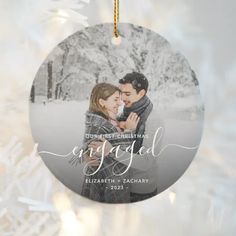 a christmas ornament with an image of a couple in the snow on it