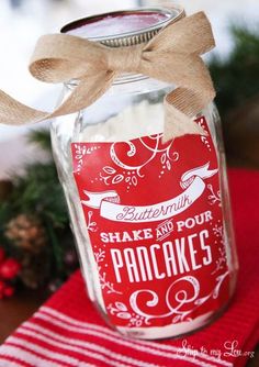 a jar filled with food sitting on top of a red napkin next to a christmas tree